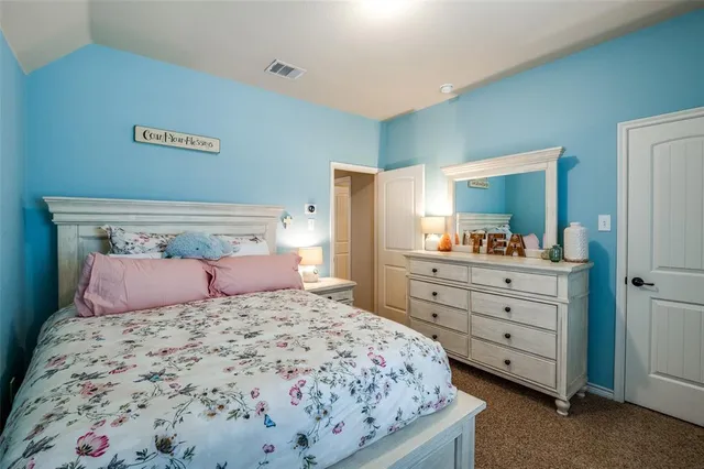 a bedroom with a large bed and a dresser