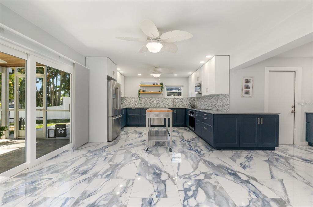 1661 Swan Terrace North Fort Myers, FL 33903 - Photo 13 of 43 a large kitchen with kitchen island a island a sink stainless steel appliances and cabinets