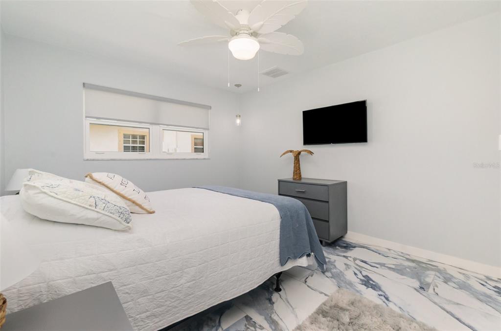 1661 Swan Terrace North Fort Myers, FL 33903 - Photo 26 of 43 a bedroom with a bed and a flat screen tv