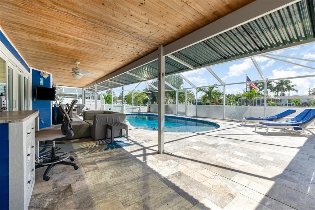 1661 Swan Terrace North Fort Myers, FL 33903 - Photo 29 of 43 a view of a patio with table and chairs under an umbrella with a barbeque