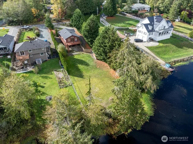 an aerial view of residential houses with outdoor space and trees all around