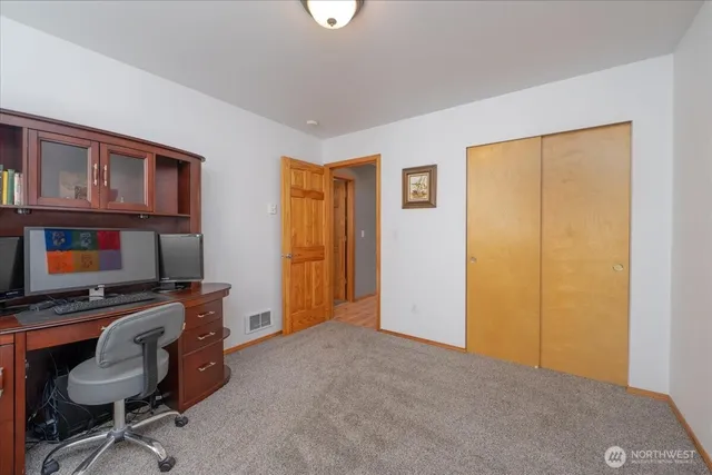 a view of a livingroom with workspace and a window