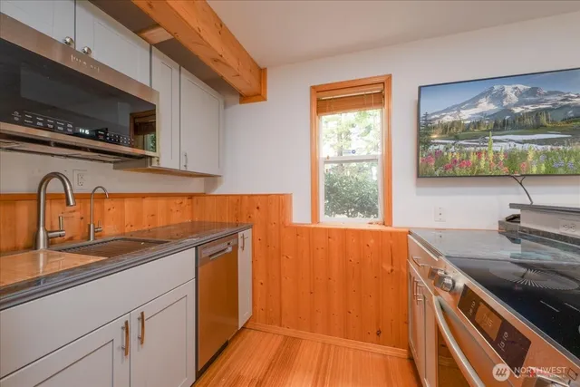 a kitchen with stainless steel appliances a sink a stove and a microwave