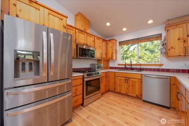 a kitchen with stainless steel appliances granite countertop a refrigerator and a stove top oven