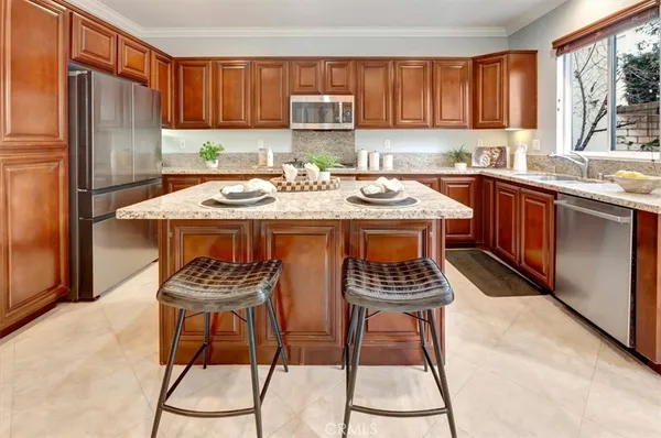 a kitchen with stainless steel appliances a sink a stove a refrigerator and cabinets