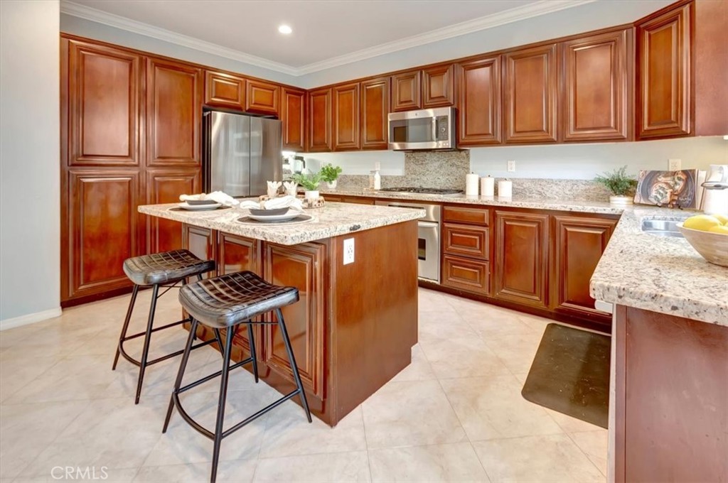 958 Baxter Parkway Brea, CA 92821 - Photo 15 of 50 a kitchen with stainless steel appliances granite countertop a stove a sink dishwasher and a refrigerator with wooden cabinets