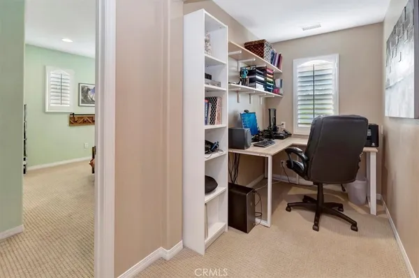 a view of a workspace with furniture and a window