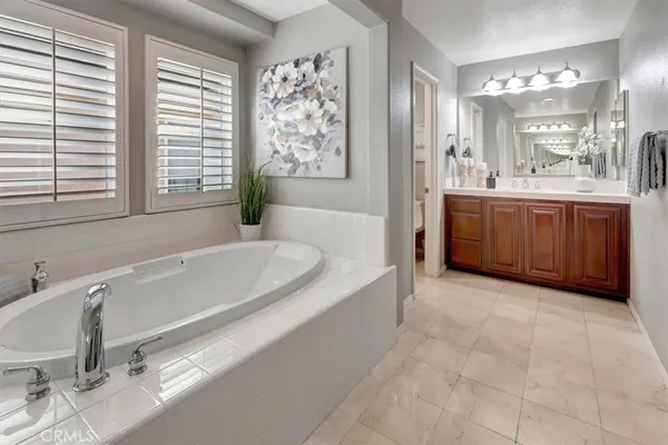 a spacious bathroom with a tub sink and mirror
