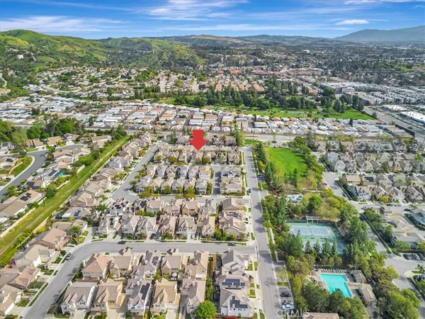 an aerial view of residential houses with outdoor space and trees