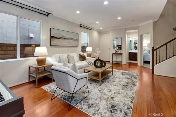 a living room with furniture and a wooden floor