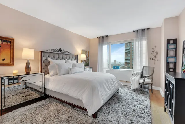 a bedroom with a bed a mirror and a window