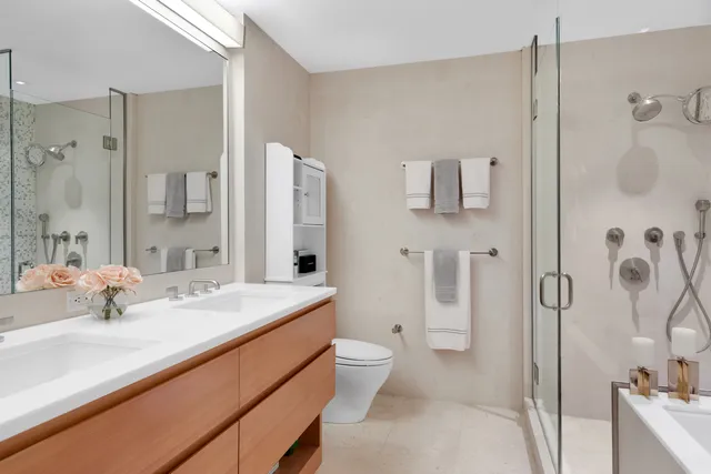 a bathroom with a sink a toilet and shower