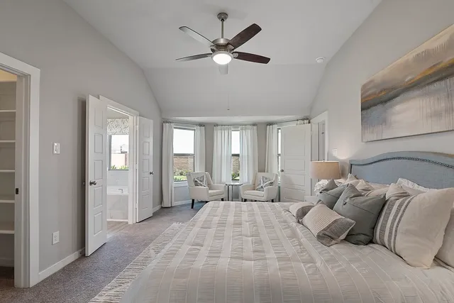 a spacious bedroom with a large bed and ceiling fan