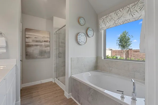 a bathroom with a tub a clock and a window