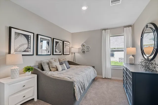 a bedroom with a bed window and dresser