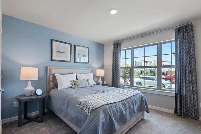 a bedroom with a large bed and a lamp next to a window