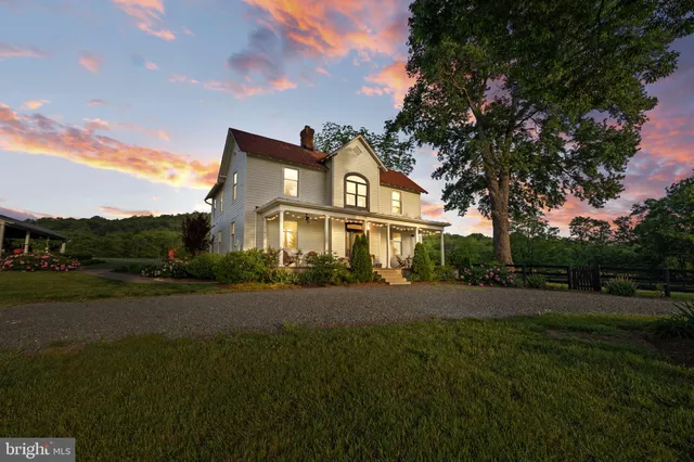 a kitchen with stainless steel appliances a stove a refrigerator a sink dishwasher and a dining table with wooden floor