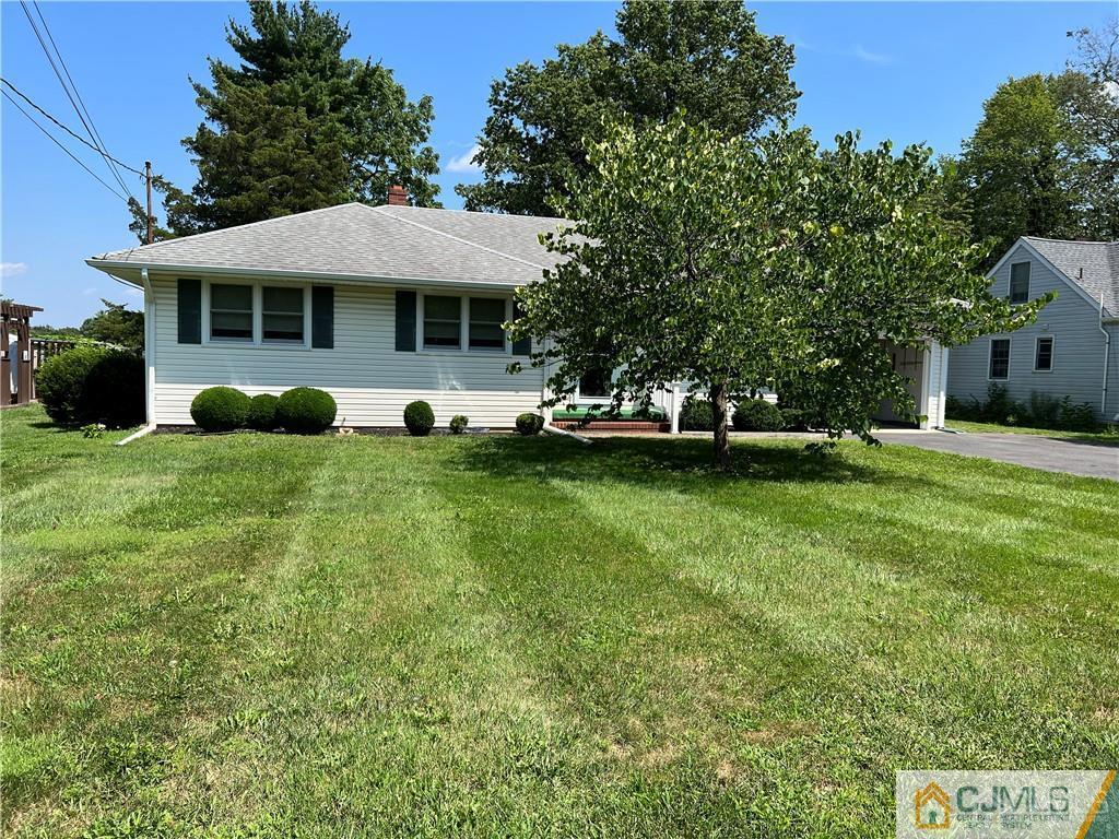 276 Georges Road Dayton, NJ 08810 - Photo 25 of 29 a front view of a house with a garden and trees