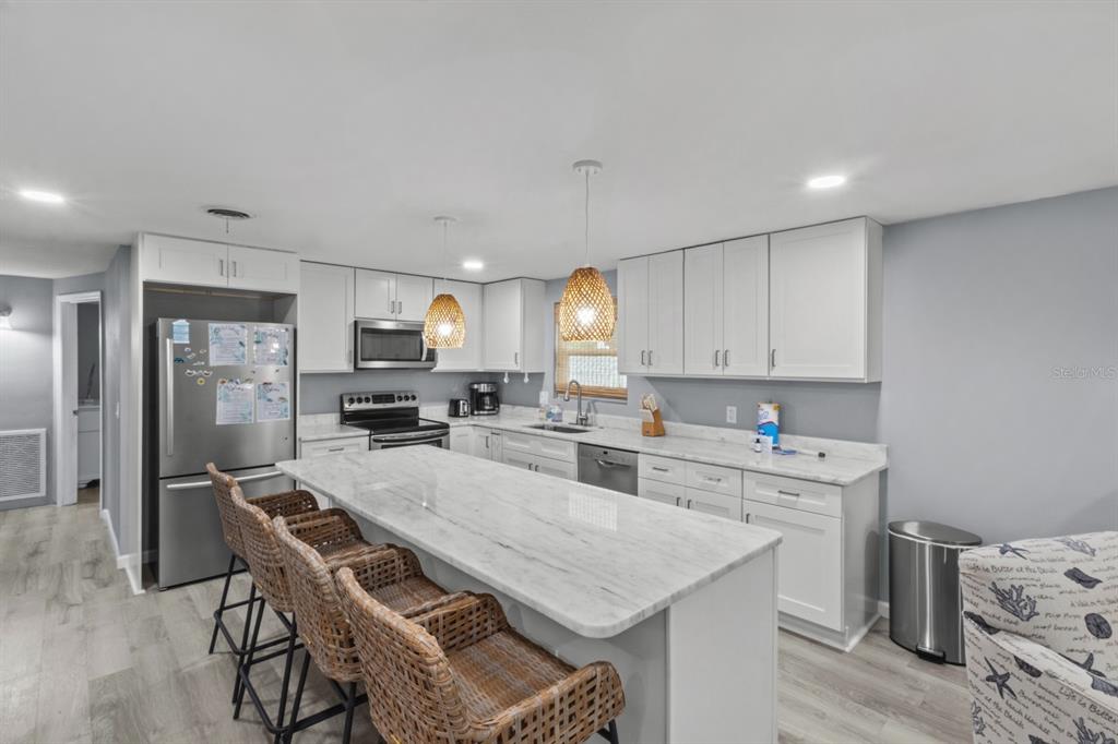 690 Fox Street Longboat Key, FL 34228 - Photo 4 of 41 a kitchen with stainless steel appliances a table and chairs in it