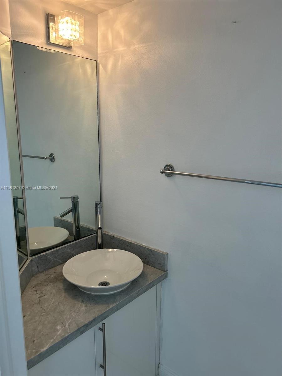 701 Brickell Key Boulevard, Unit 202 Miami, FL 33131 - Photo 16 of 27 a bathroom with a granite countertop sink and a mirror