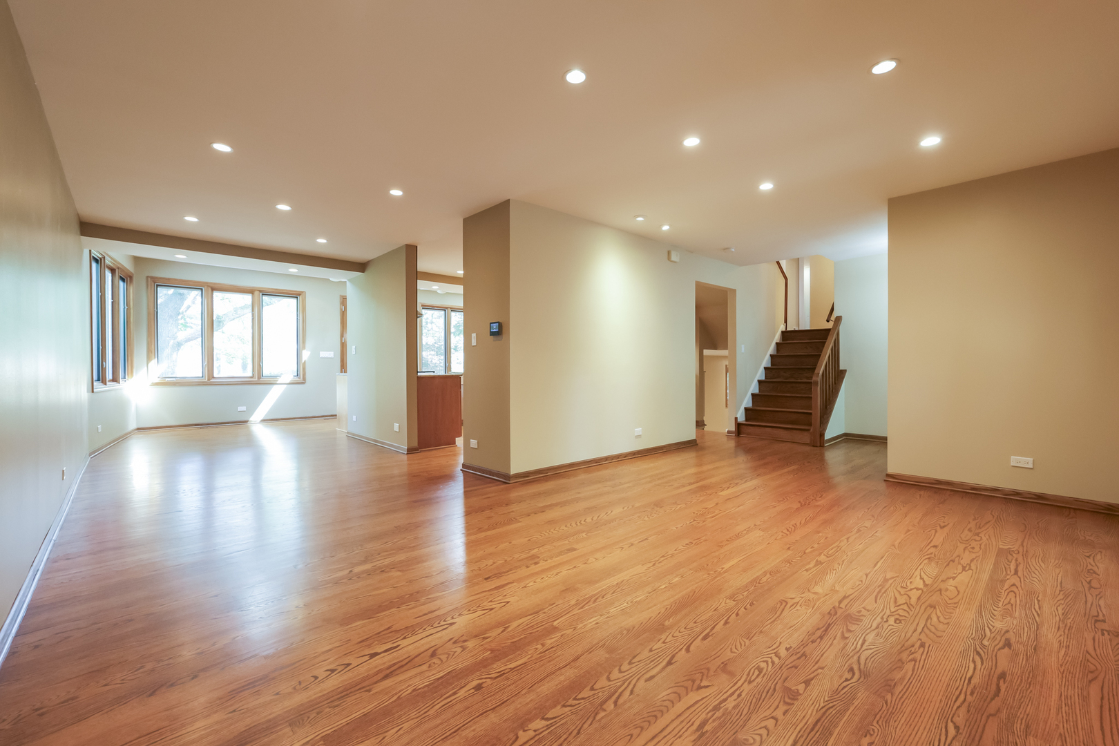 3206 Maple Leaf Drive Glenview, IL 60026 - Photo 21 of 45 a view of an empty room with wooden floor and a kitchen