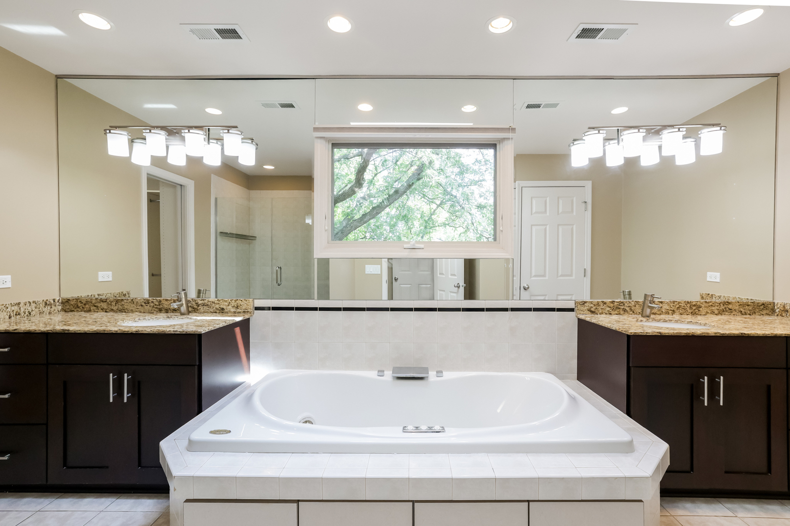 3206 Maple Leaf Drive Glenview, IL 60026 - Photo 31 of 45 a bathroom with a bathtub a double vanity sink and a large mirror