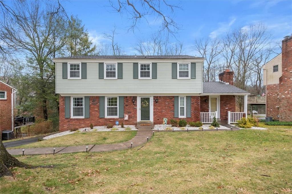 a front view of a house with swimming pool and chairs