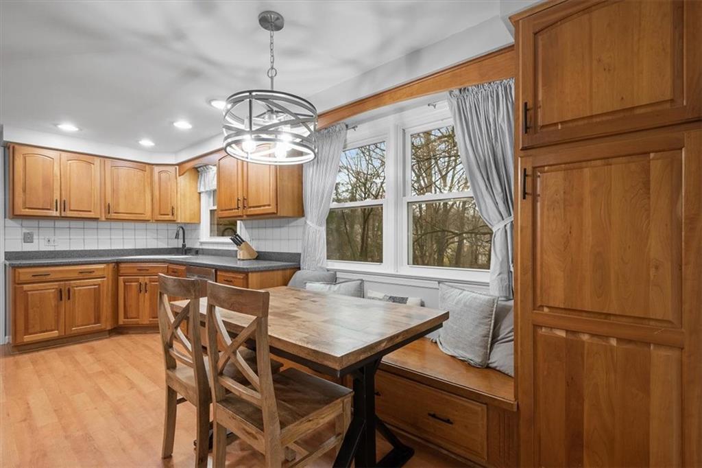 9350 Timber Trail Pittsburgh, PA 15237 - Photo 18 of 38 a kitchen with a refrigerator a sink dishwasher a dining table and chairs with wooden floor