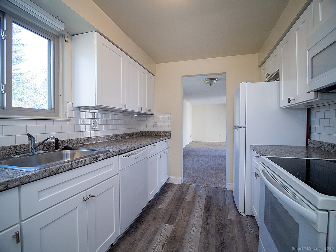a kitchen with a sink a stove a refrigerator and cabinets