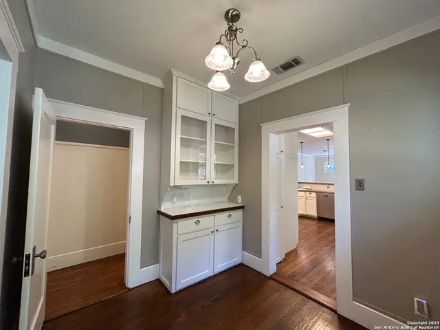 an open kitchen with granite countertop cabinets table and chairs