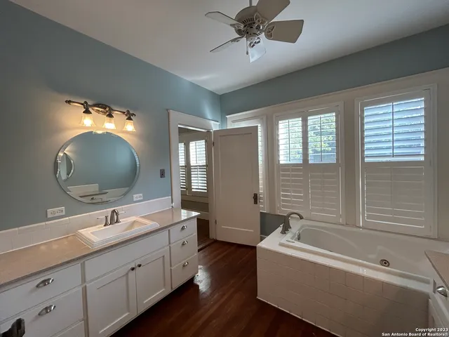 a bathroom with a sink a tub and a mirror