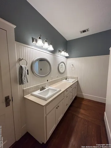 a bathroom with a double vanity sink and a mirror