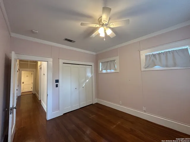 an empty room with wooden floor and windows