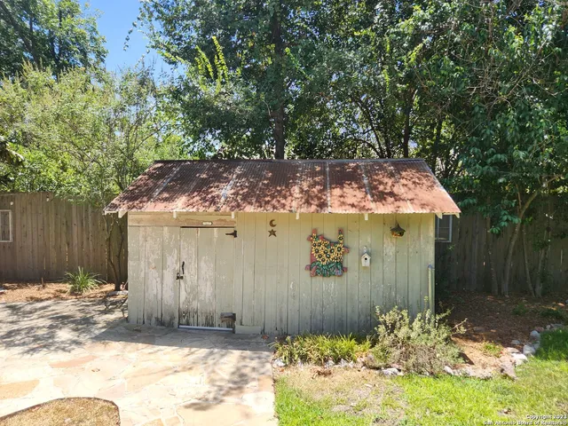 a view of backyard with wooden fence and trees