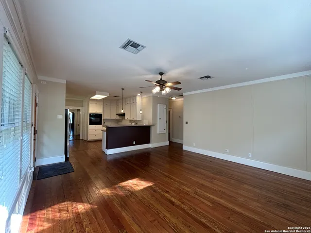 a view of a kitchen with wooden floor and a kitchen space