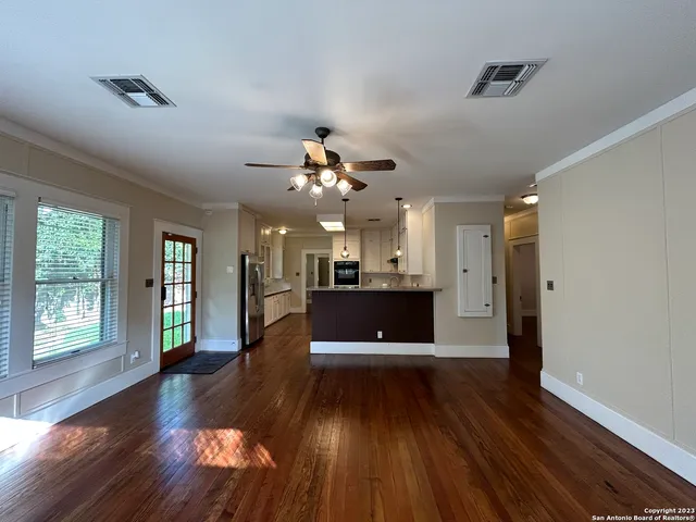 an empty room with wooden floor and windows
