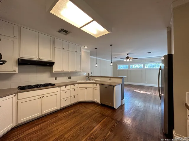 a kitchen with white cabinets and sink