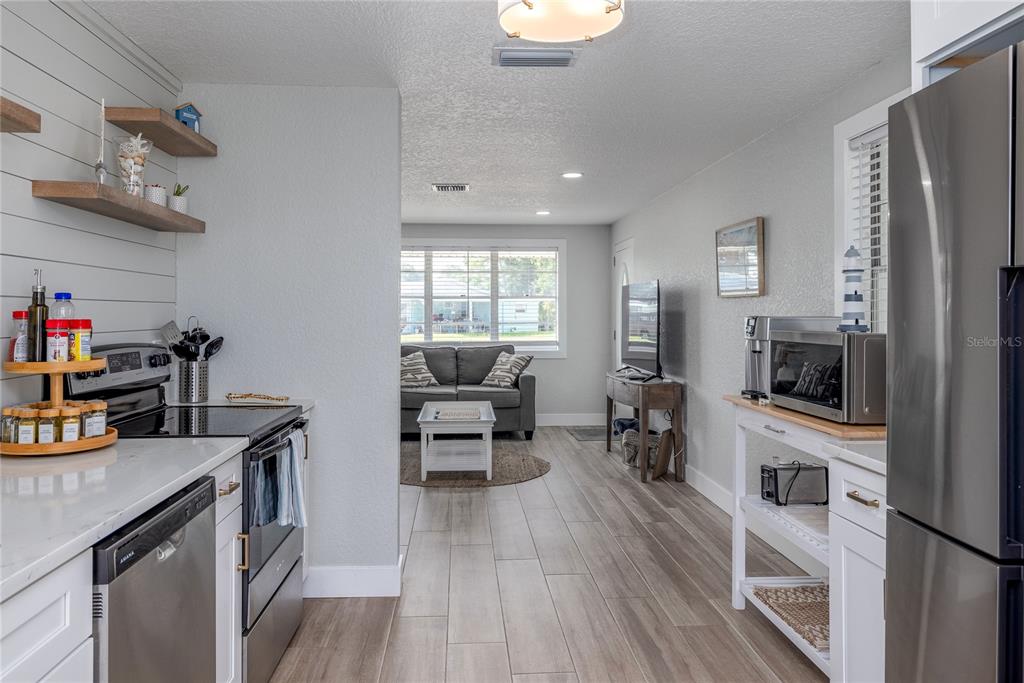 54 Rivershore Drive Ormond Beach, FL 32176 - Photo 9 of 38 a kitchen with stainless steel appliances a stove top oven a sink a dining table and chairs