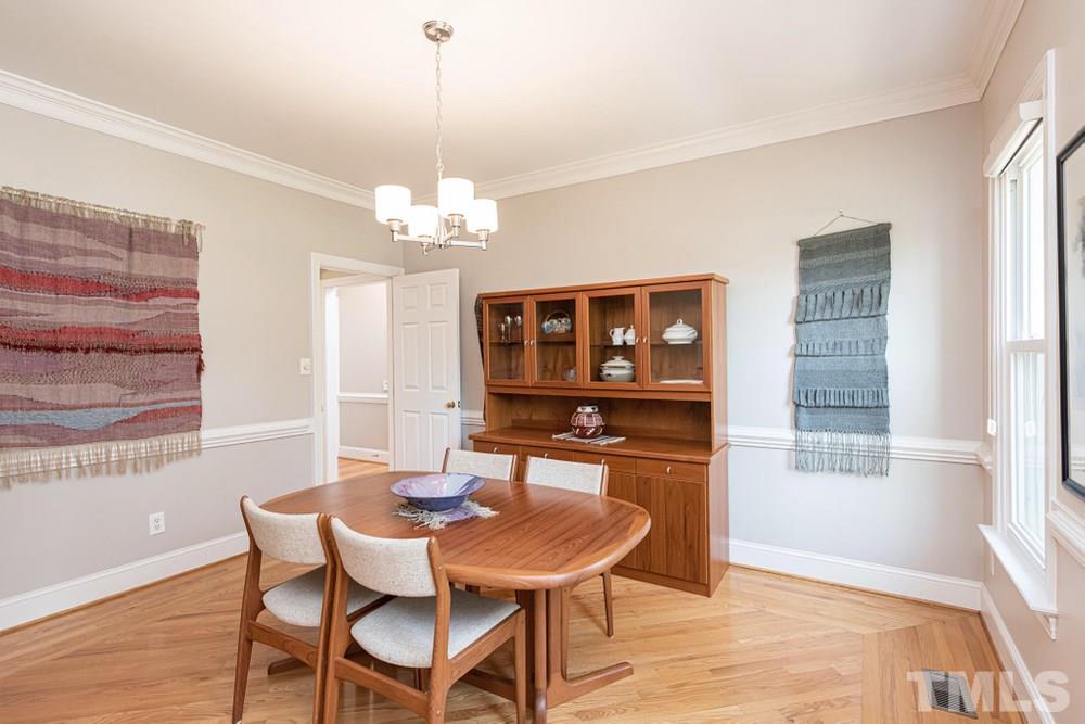 204 Reedham Way Raleigh, NC 27615 - Photo 10 of 30 Separate Dining Room off Foyer with chair railing, crown molding, and tall front windows.