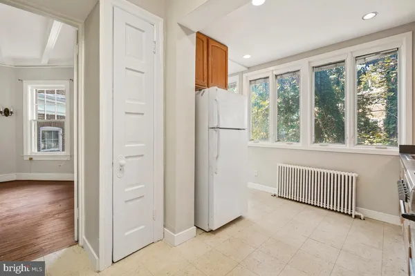 a view of kitchen with furniture and refrigerator