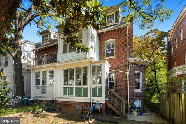 a front view of a house with a tree