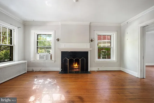 a view of an empty room with window and fire place