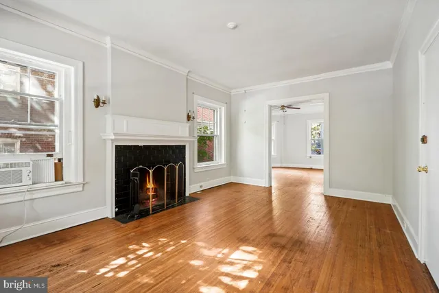 a view of a livingroom with wooden floor and a fireplace