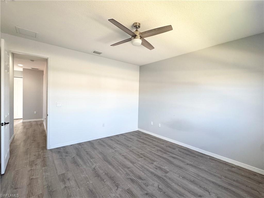 8984 Madrid Circle Naples, FL 34104 - Photo 17 of 28 an empty room with wooden floor and windows
