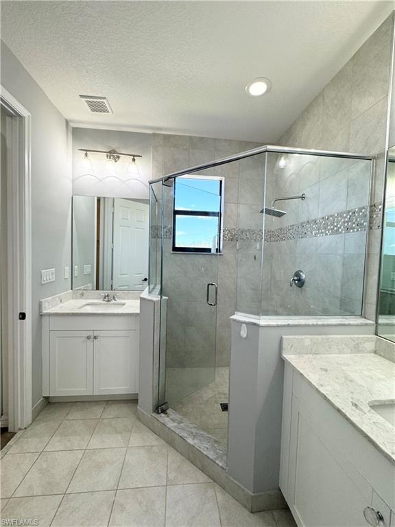 8984 Madrid Circle Naples, FL 34104 - Photo 20 of 28 a bathroom with a granite countertop sink mirror and shower