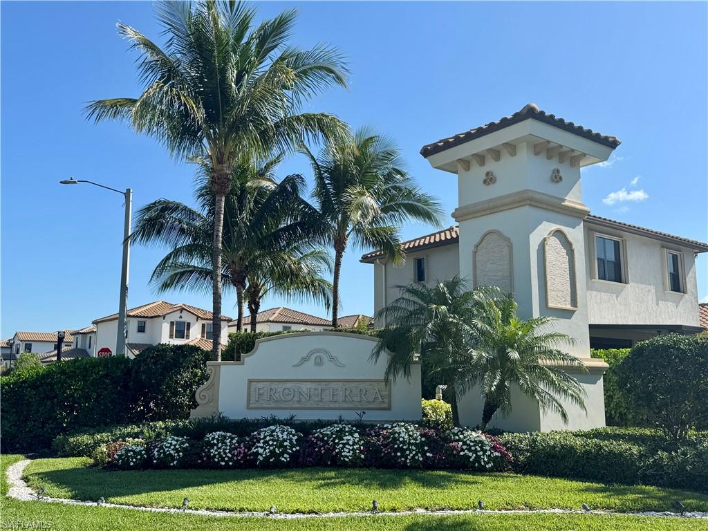 8984 Madrid Circle Naples, FL 34104 - Photo 26 of 28 a front view of a house with a yard and potted plants