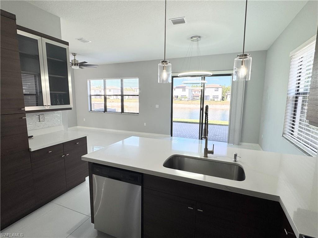 8984 Madrid Circle Naples, FL 34104 - Photo 6 of 28 a kitchen with stainless steel appliances granite countertop a sink and a window