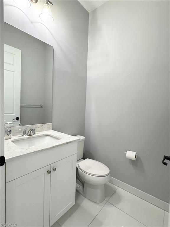 8984 Madrid Circle Naples, FL 34104 - Photo 8 of 28 a bathroom with a sink a toilet and mirror