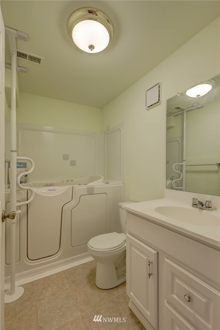 406 Stevens Avenue Northwest Renton, WA 98057 - Photo 22 of 24 a bathroom with a granite countertop toilet sink and mirror