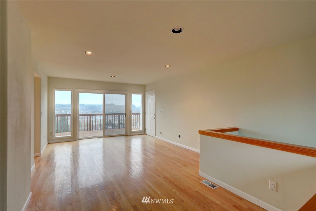 406 Stevens Avenue Northwest Renton, WA 98057 - Photo 4 of 24 a view of an empty room with wooden floor and a window